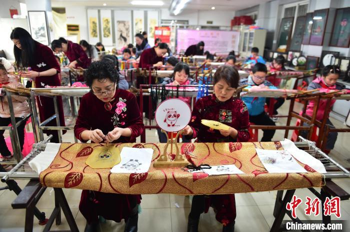 江西省級非遺豫章繡傳承人手把手指導小學生繡制2022年北京冬奧會吉祥物“冰墩墩”形象?！∮髟屏?攝