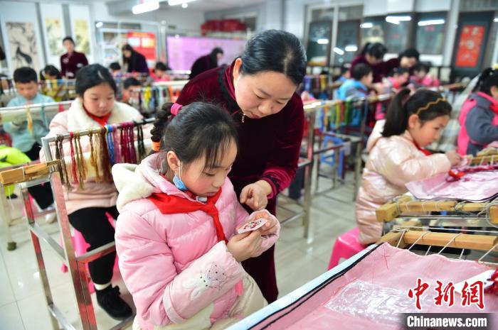 江西省級非遺豫章繡傳承人手把手指導小學生繡制2022年北京冬奧會吉祥物“冰墩墩”形象?！∮髟屏?攝