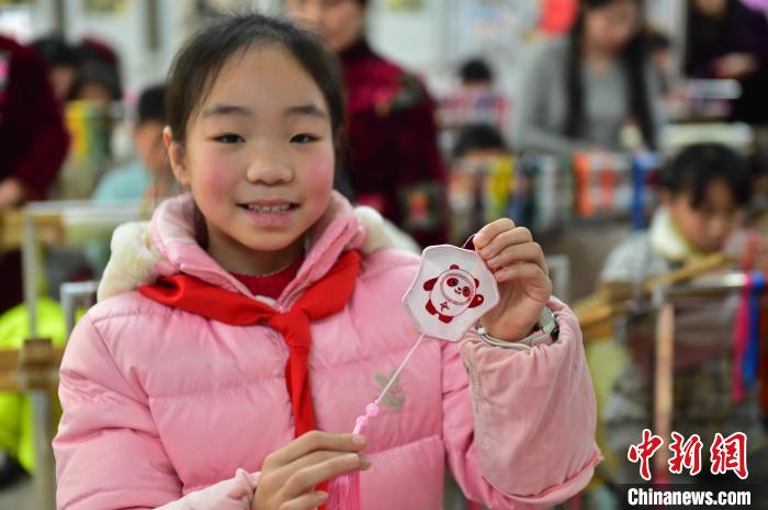 圖為一名小學生繡制的2022年北京冬奧會吉祥物“冰墩墩”形象。　喻云亮 攝