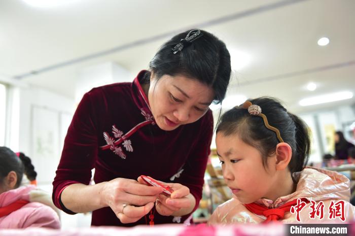 江西省級非遺豫章繡傳承人手把手指導小學生繡制2022年北京冬奧會吉祥物“冰墩墩”形象?！∮髟屏?攝