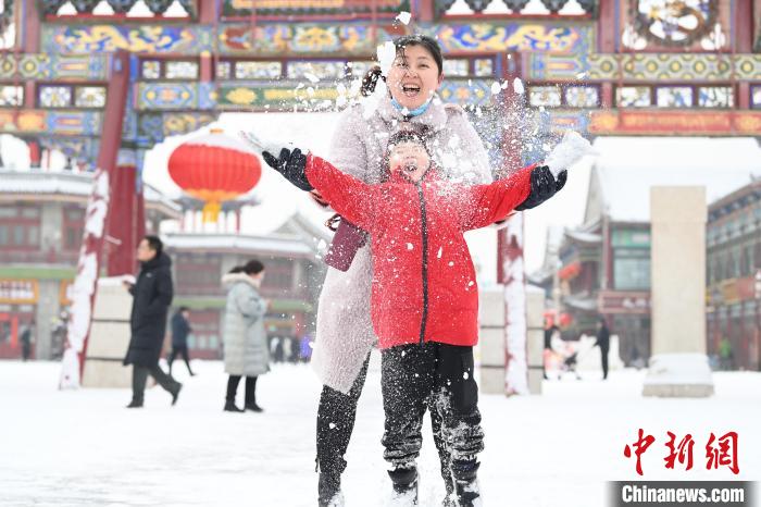 2月13日，家長與小朋友在呼和浩特市大召廣場享雪趣?！⑽娜A 攝