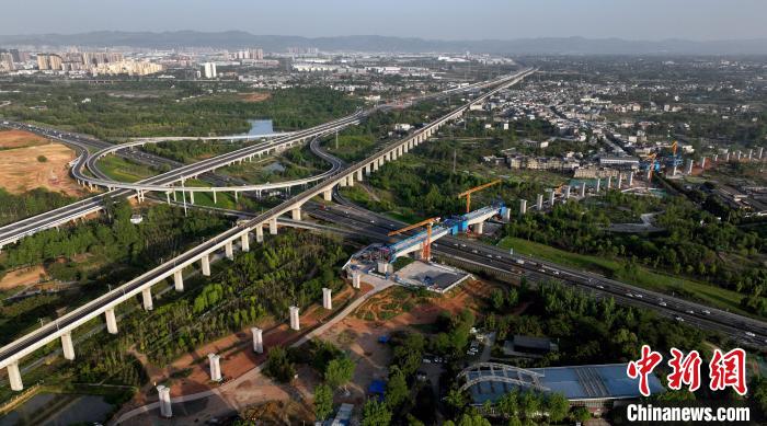 航拍正在建設(shè)的跨越成都繞城高速公路連續(xù)梁施工現(xiàn)場(chǎng)，旁邊依次為已運(yùn)營(yíng)的成渝高速鐵路和機(jī)場(chǎng)高速公路?！⒅铱?攝