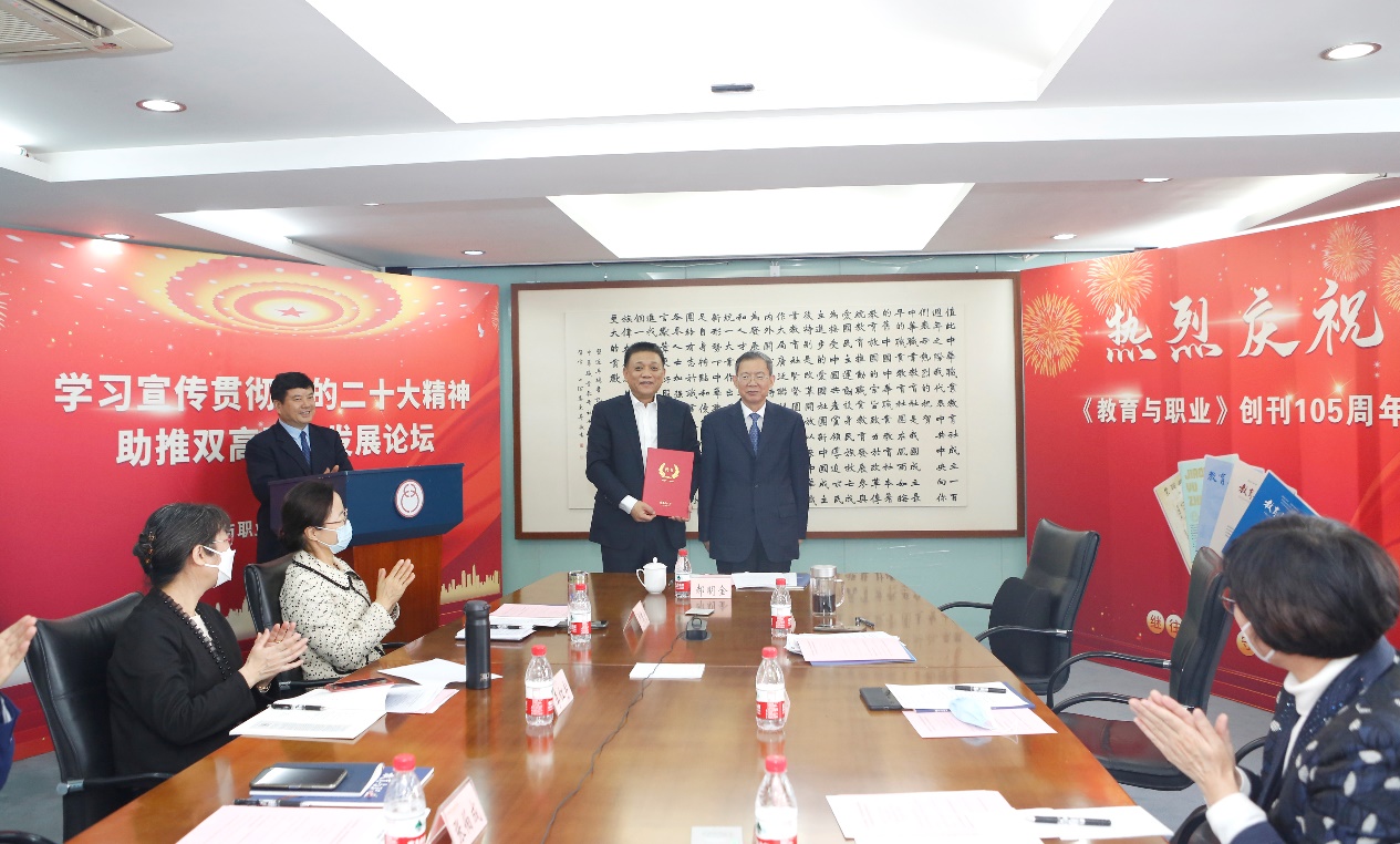 郝明金為《教育與職業(yè)》雜志編委代表陳曉明頒發(fā)聘書。中華職教社供圖