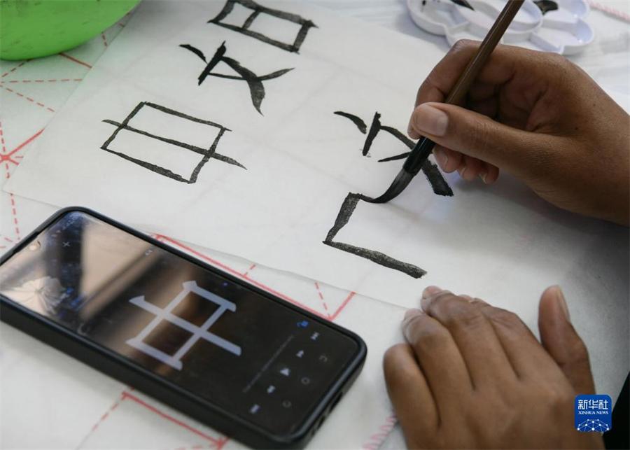 4月18日，肯尼亞學(xué)生在內(nèi)羅畢大學(xué)孔子學(xué)院舉辦的活動上寫毛筆字?？夏醽唭?nèi)羅畢大學(xué)孔子學(xué)院18日舉辦“中文，增進文明對話”主題活動，慶祝即將到來的第14個聯(lián)合國中文日?？夏醽唽W(xué)生參與互動，進行書法、剪紙、唱中文歌等活動。新華社記者 韓旭 攝