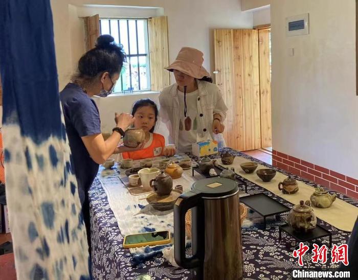 圖為：游客正在咨詢臺(tái)灣柴燒作品?！∪~秋云 攝