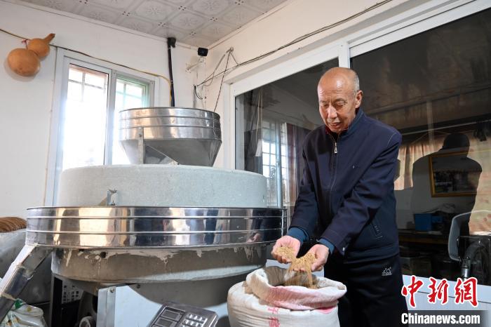李家莊村民谷文朝重拾父輩的手藝，做起石磨面粉的營生?！〉杂鸺?攝