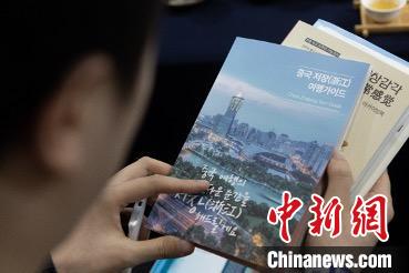 參展觀眾閱讀浙江文旅手冊。　丁振哲 攝