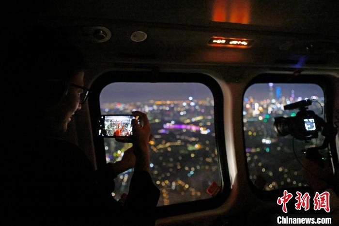6月3日晚，游客乘坐上海新空直升機(jī)有限公司直升機(jī)開啟鳥瞰黃浦江空中圓夢之旅，并用手機(jī)拍攝城市夜景。　殷立勤 攝