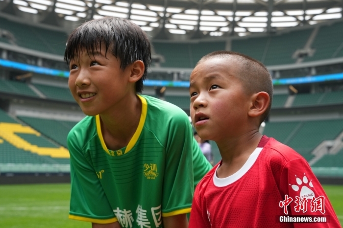 圖為北京國(guó)安小球員陳小北和7歲的俄金仁增在一起觀看場(chǎng)內(nèi)播放的紀(jì)錄片。<a target='_blank' href='/' _fcksavedurl='/'><p  align=