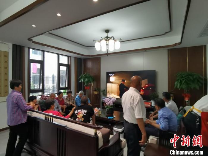 親友們集中在費(fèi)俊龍家中觀看返程的視頻?！＄娚?攝