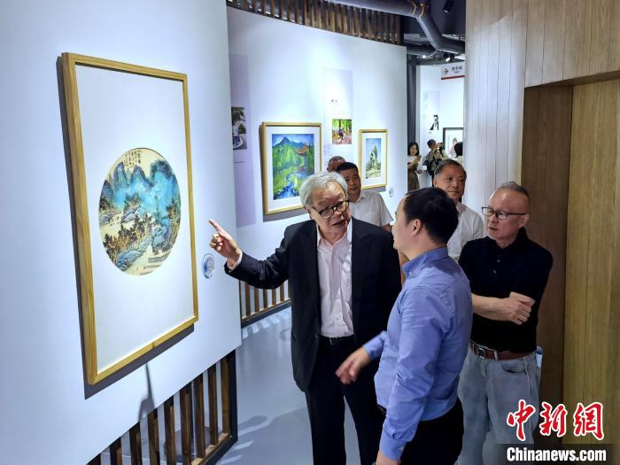 海峽兩岸藝術(shù)家畫展上，藝術(shù)家進(jìn)行藝術(shù)交流?！「毒窜?攝