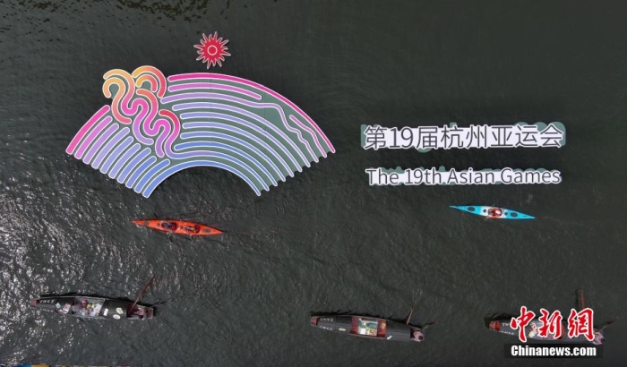 資料圖為烏篷船和皮劃艇從杭州亞運會標(biāo)識前劃過。王剛 攝