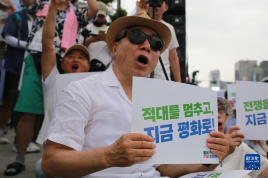7月22日，在韓國首爾，人們手舉標(biāo)語參與反戰(zhàn)游行。新華社發(fā)（楊暢 攝）