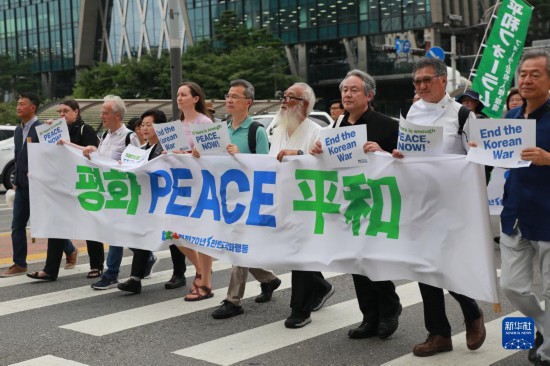 7月22日，在韓國首爾，人們手舉標(biāo)語參與反戰(zhàn)游行。新華社發(fā)（楊暢 攝）