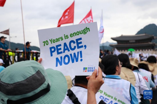 7月22日，在韓國首爾，人們手舉標(biāo)語參與反戰(zhàn)游行。新華社發(fā)（楊暢 攝）