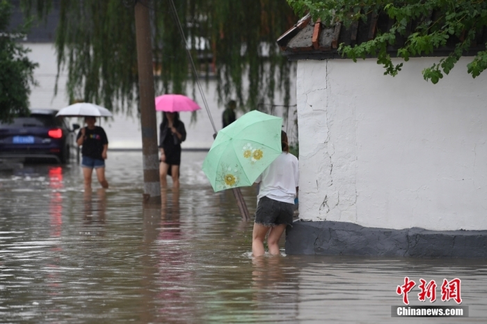 7月31日，市民行走在雨中的北京房山區(qū)瓦窯頭村。北京市氣象臺(tái)當(dāng)日10時(shí)發(fā)布分區(qū)域暴雨紅色預(yù)警信號。北京市水文總站發(fā)布洪水紅色預(yù)警，預(yù)計(jì)當(dāng)日12時(shí)至14時(shí)，房山區(qū)大石河流域?qū)⒊霈F(xiàn)紅色預(yù)警標(biāo)準(zhǔn)洪水。<a target='_blank' href='/'><p  align=