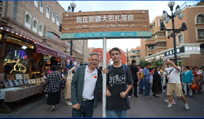 潘維廉和維吾爾族青年伊木蘭“打卡”大巴扎。主辦方供圖
