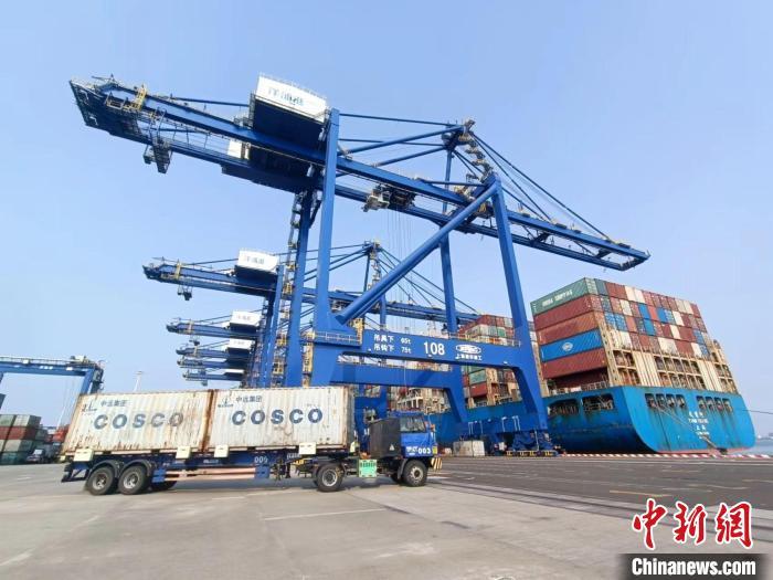 圖為海南洋浦國際集裝箱碼頭，卡車將集裝箱從后方堆場運往碼頭裝卸區(qū)?！堅潞?攝