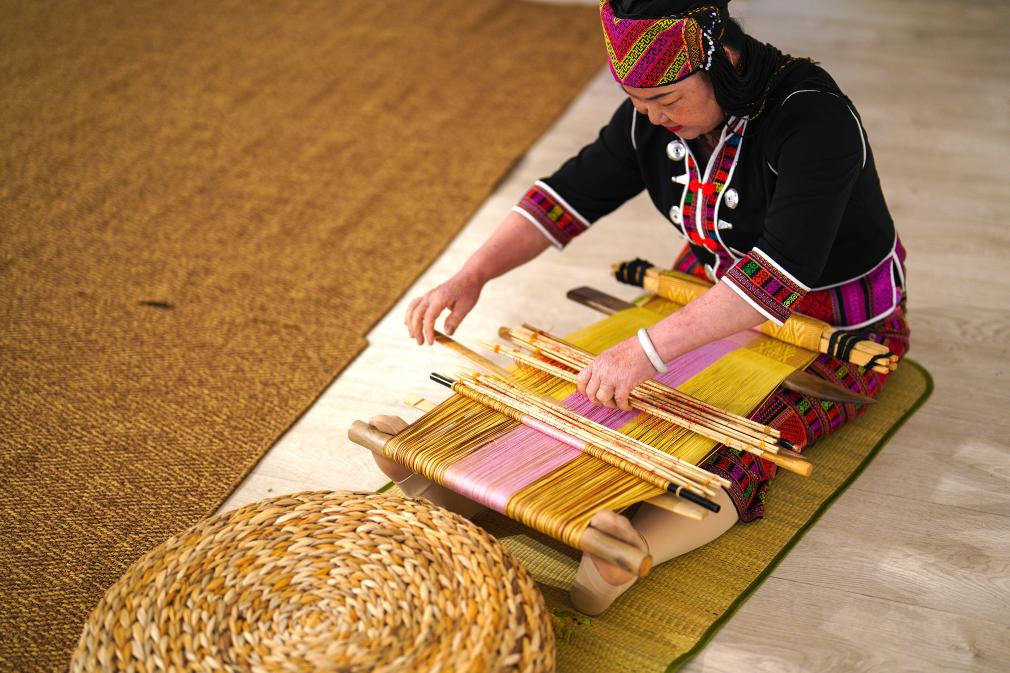 4月17日，黎族傳統(tǒng)紡染織繡技藝國(guó)家級(jí)代表性傳承人劉香蘭在2023年意大利米蘭設(shè)計(jì)周上展示黎錦織造技藝。新華社發(fā)