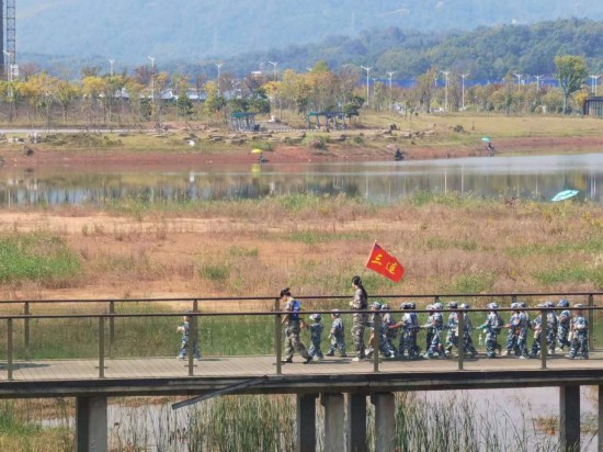 　　10月24日，秋游的幼兒園小朋友在老師帶領(lǐng)下走在清水塘公園里的木橋上。本報(bào)記者 常雯宜攝