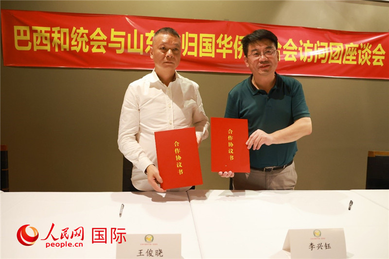 中國僑聯(lián)副主席、山東省僑聯(lián)主席李興鈺（右）與巴西和統(tǒng)會(huì)會(huì)長(zhǎng)王俊曉簽署合作協(xié)議書。人民網(wǎng)記者 陳海琪攝