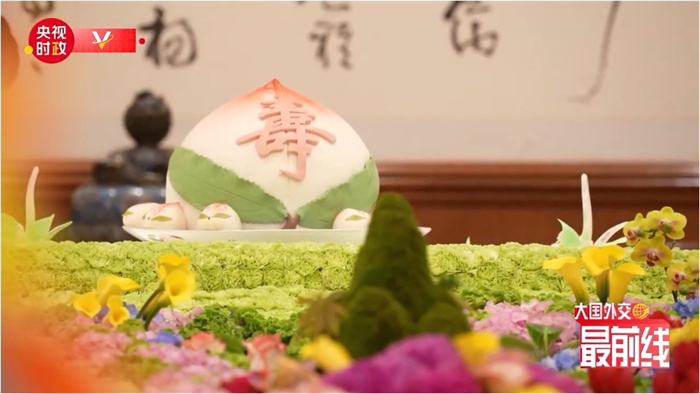 圖為今年7月基辛格訪華時(shí)午宴上的壽桃。來(lái)源：央視新聞截圖
