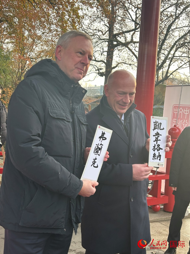 柏林市長(zhǎng)韋格納（右）、動(dòng)物園監(jiān)事會(huì)主席布魯克曼（左）手持中國(guó)文化中心工作人員現(xiàn)場(chǎng)手書的中文名字。人民網(wǎng)記者 徐馨攝