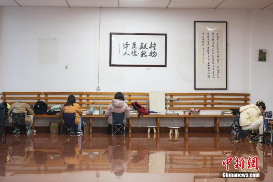 資料圖：幾位考研學(xué)生在南昌大學(xué)教學(xué)樓的公共空間復(fù)習(xí)備考。劉力鑫 攝