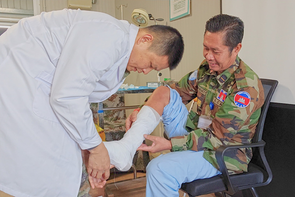中國第22批赴黎維和醫(yī)療分隊軍醫(yī)為患者打石膏固定患肢。李清竹攝