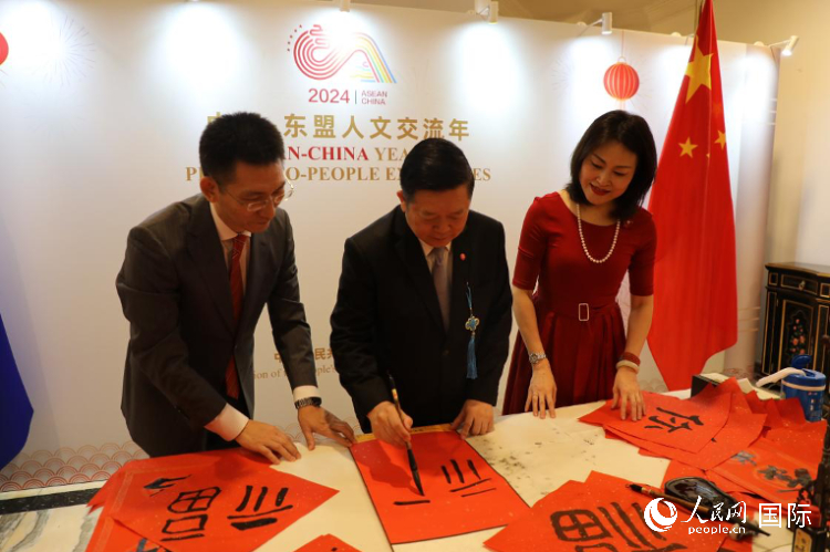 東盟秘書(shū)長(zhǎng)高金洪（中）在活動(dòng)現(xiàn)場(chǎng)寫(xiě)福字。人民網(wǎng)記者曹師韻攝