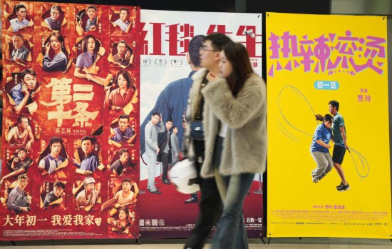 這是2月17日，在沈陽一家影院，觀眾從海報前經(jīng)過。新華社記者李鋼攝