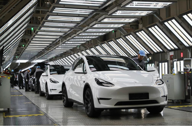 2023年12月22日，在特斯拉上海超級工廠內，工人在對出廠前的車輛進行漆面及門窗檢測。新華社記者 方喆 攝