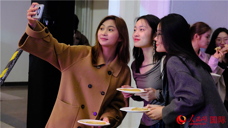 中國觀眾在現(xiàn)場品嘗“謝肉節(jié)”節(jié)日美食——煎薄餅。人民網(wǎng) 褚夢琦攝