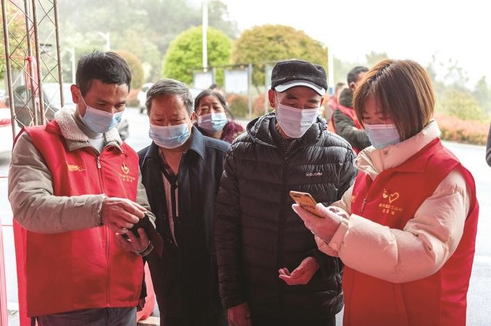 長沙縣黨員志愿者正在幫助參與核酸檢測的群眾掃描“場所碼”。劉思源 攝