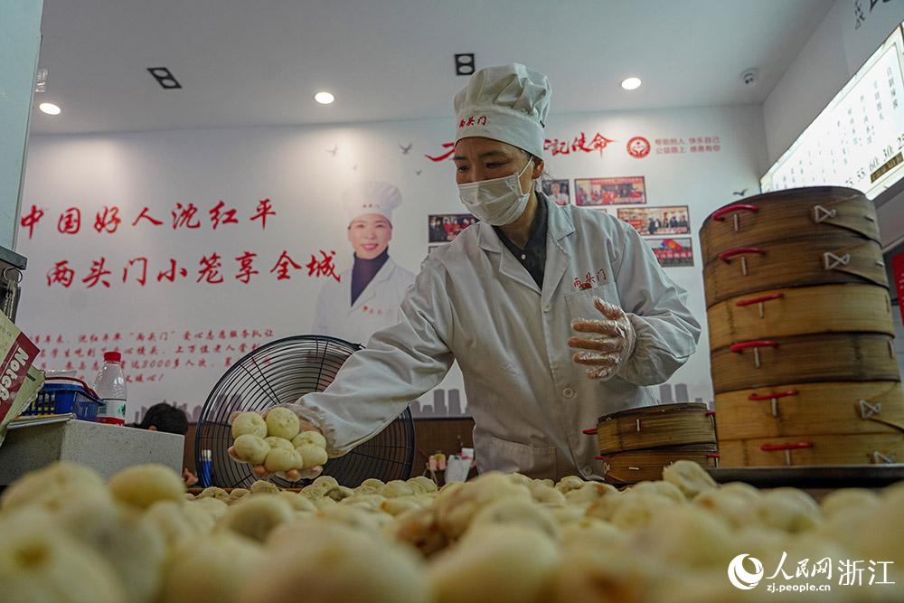 3月31日，在浙江省嵊州市甘霖鎮(zhèn)，嵊州小吃從業(yè)者沈紅平把蒸熟的小籠包晾涼，打包冷藏售賣。人民網(wǎng) 章勇濤攝
