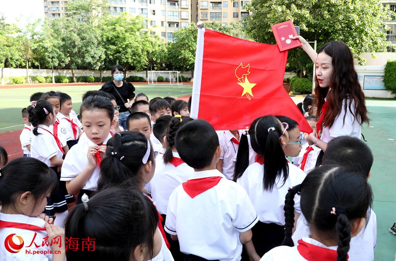 老師向少先隊(duì)員展示隊(duì)旗。人民網(wǎng) 符武平攝