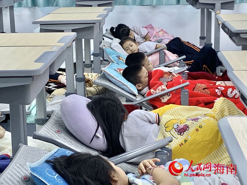 海口第二十六小學(xué)學(xué)生在新式課桌椅上午休。人民網(wǎng) 李浩蓉?cái)z