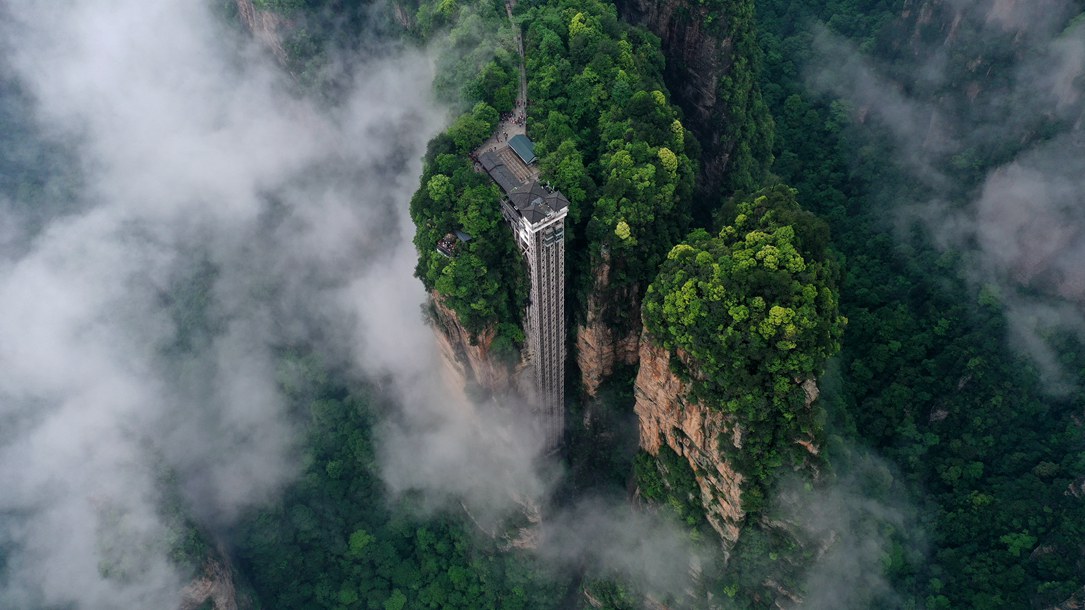 位于張家界武陵源景區(qū)的百龍?zhí)焯蓁偳对谠旗F繚繞的峰林間，雄偉壯觀。吳勇兵攝