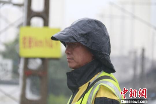 蘭州西工務(wù)段蘭州線路車間防護(hù)員雨中巡查?！⊥豕廨x 攝