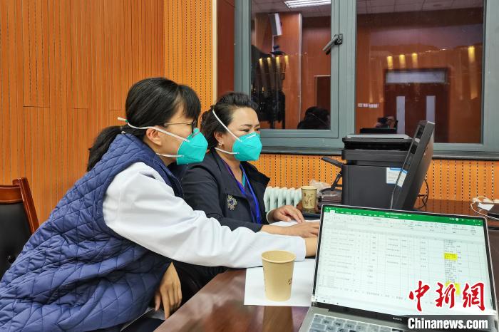 8月9日，楊蘇喬(左)在拉薩方艙醫(yī)院指揮部讀取艙內(nèi)患者胸部CT?！∈茉L者供圖