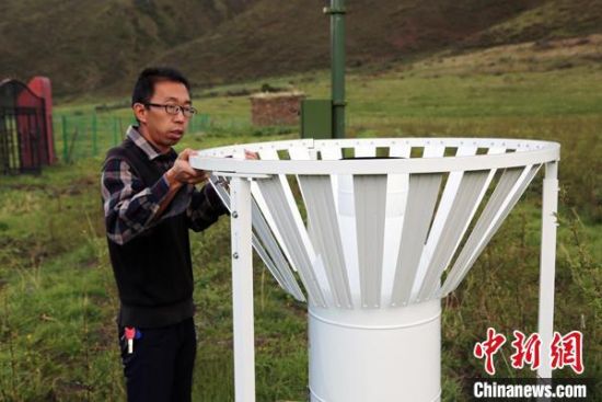 圖為班瑪縣氣象局工作人員在維護(hù)藏雪茶基地氣候站。青海省氣象局供圖