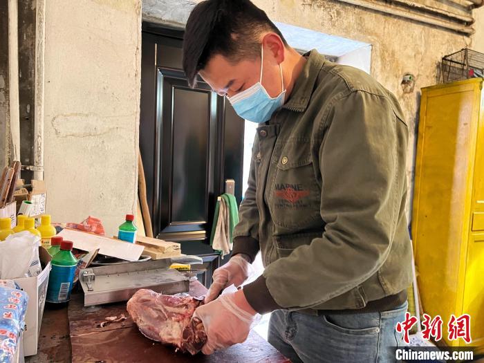 圖為雪豹“奶爸”史壽軍正在準(zhǔn)備投喂雪豹的食材?！●R銘言 攝