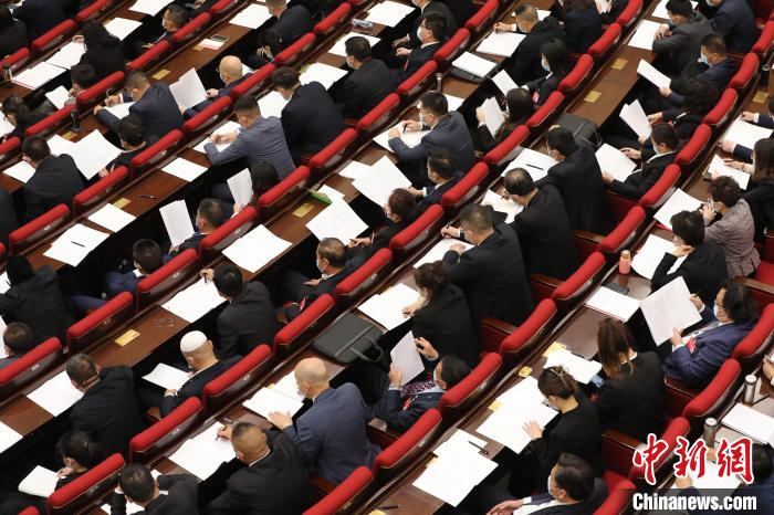圖為會議現(xiàn)場，參會代表正在聽取政府工作報告?！∑钤鲚?攝