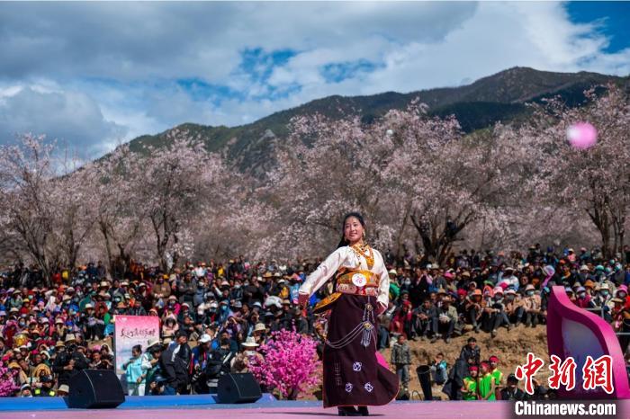 桃花林下精彩的“桃花仙子”選拔吸引村民或游客。　劉忠俊 攝
