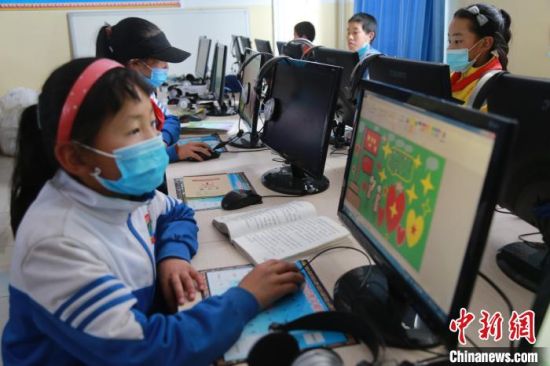 圖為鄉(xiāng)村學校少年宮的孩子們正在上電腦課。　才讓本　攝