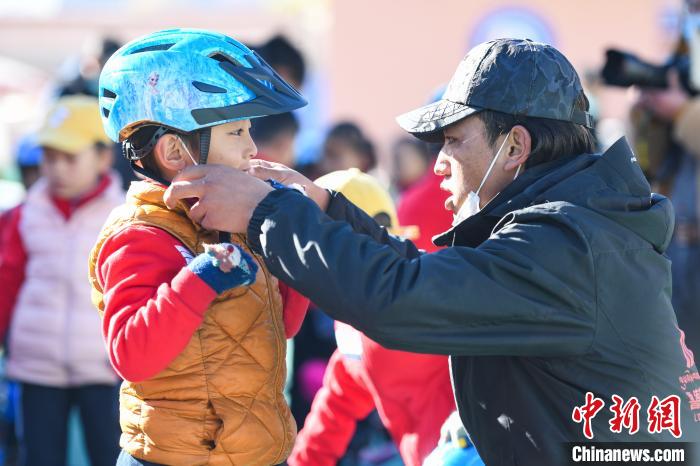 圖為拉薩市實驗幼兒園孩子在教練的幫助下穿戴頭盔。　何蓬磊 攝