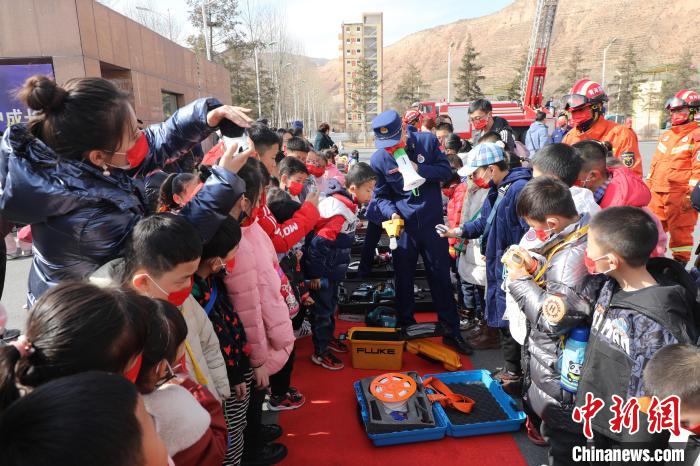 圖為小朋友們聽消防員講解消防器材?！铨埥?攝