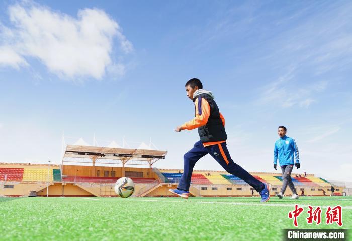 圖為一名男孩運(yùn)球射門?！●R銘言 攝