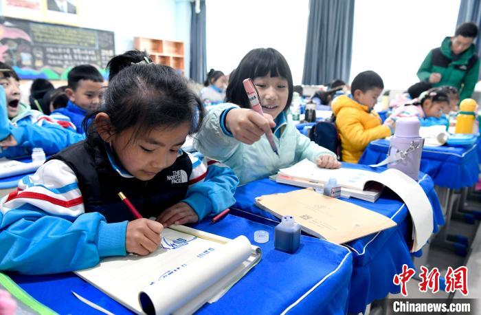 3月14日，西藏拉薩市第一小學(xué)一年級(jí)六班學(xué)生白瑪朗珍(圖左)在藏語(yǔ)文課上書(shū)寫(xiě)藏文?！±盍?攝
