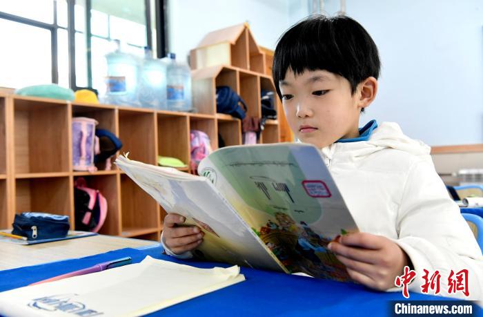 3月14日，西藏拉薩市第一小學(xué)一年級(jí)六班學(xué)生丁增樂(lè)吉在閱讀藏語(yǔ)課本?！±盍?攝